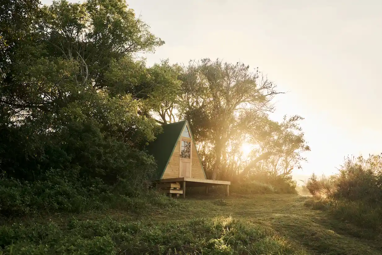 Stunning sunset over Bodhi Khaya Nature Retreat with a building in the foreground, South Africa.