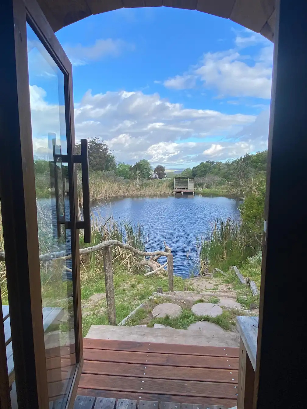 Serene view of a tranquil pond from the doorway at Bodhi Khaya Nature Retreat, South Africa.